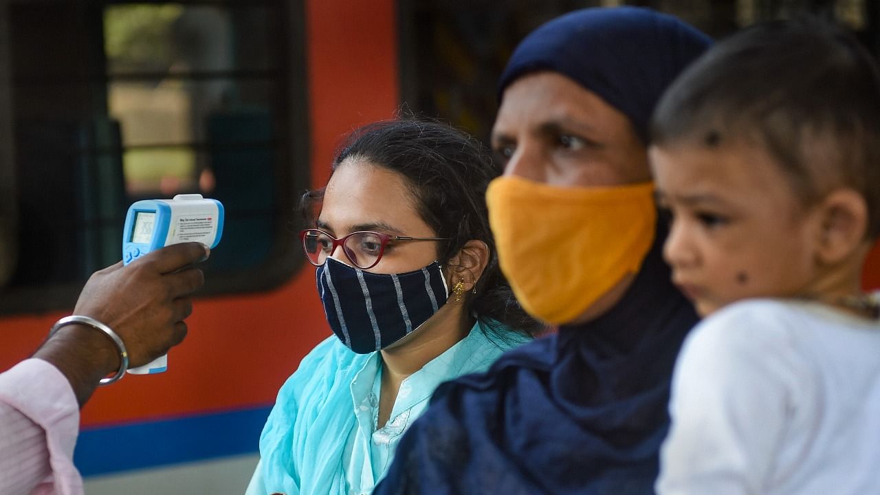 A BMC health worker conducts thermal screening of the outstation passengers for Covid-19 testing at Dadar Railway Station in Mumbai, Wednesday, November 3, 2021. Credit: PTI Photo