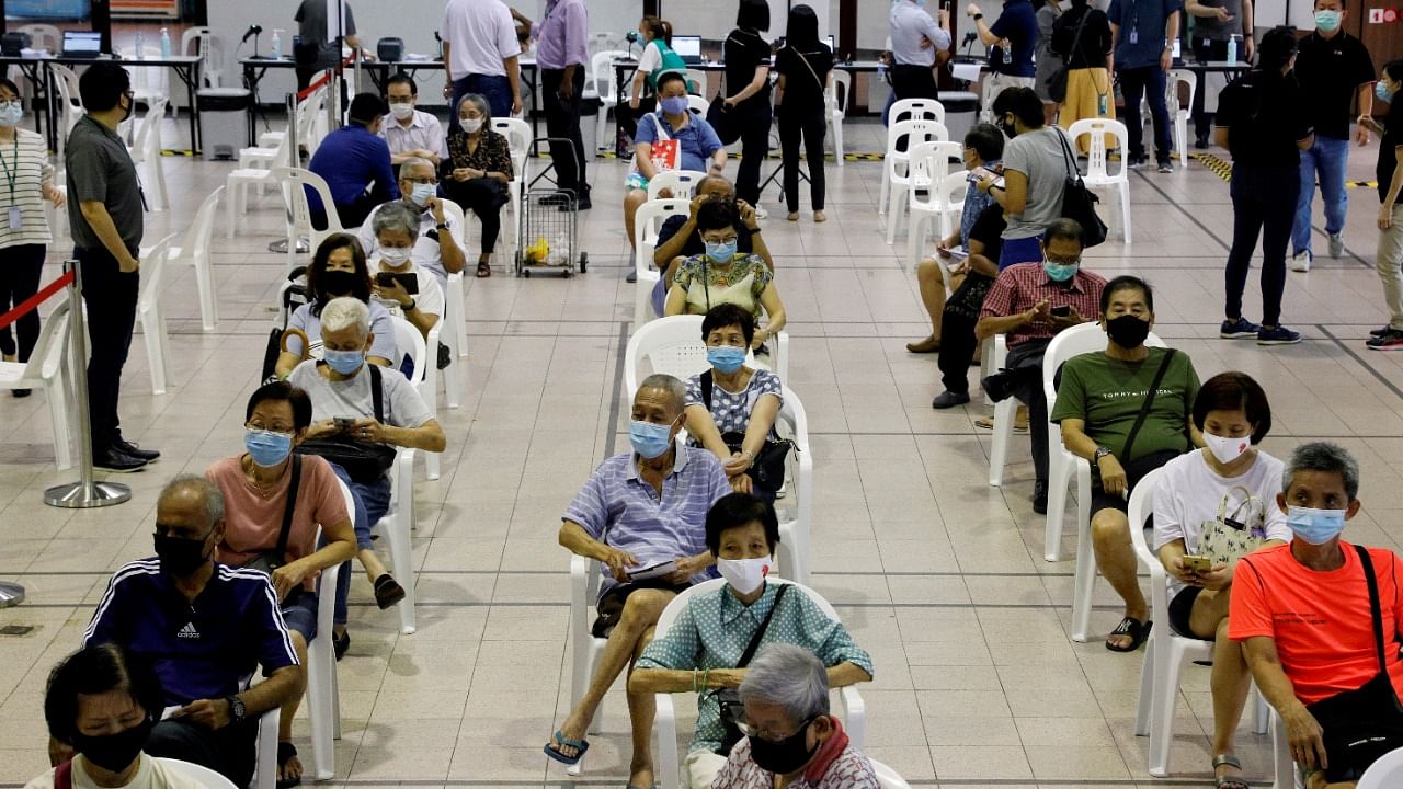 People above 70 years old wait in an observation area after getting a dose of the coronavirus disease (Covid-19) vaccine at a vaccination centre in Singapore. Credit: Reuters File Photo