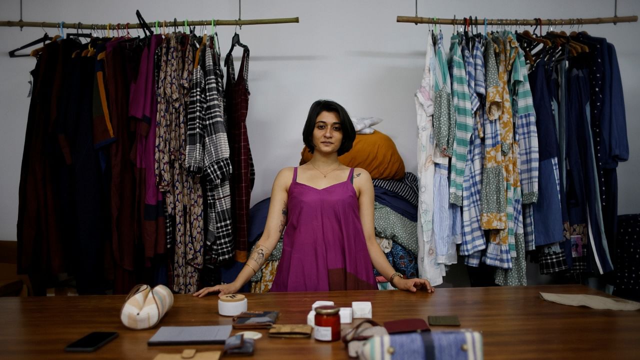 Kriti Tula, a fashion designer, poses for a picture as she stands next to the clothes made from discarded fabric waste, at her factory in New Delhi. Credit: Reuters Photo