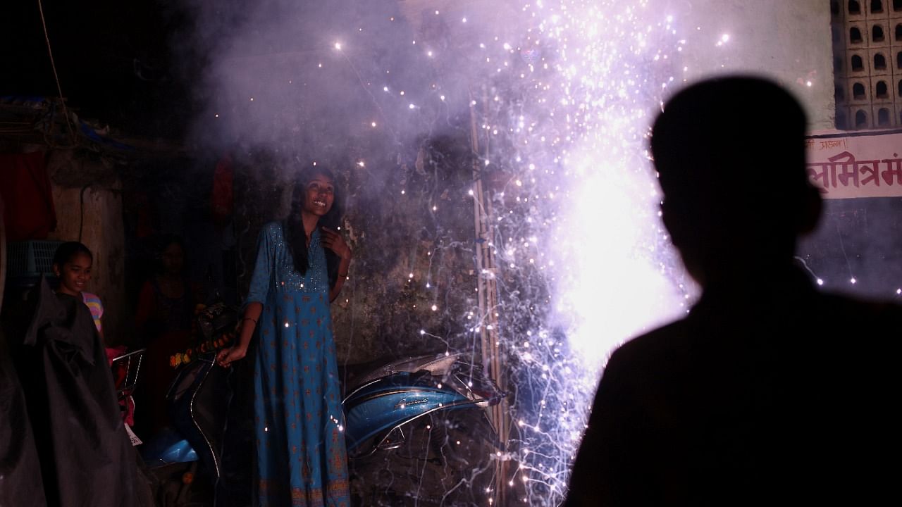 People watch as firecrackers burn during Diwali. Credit: Reuters Photo