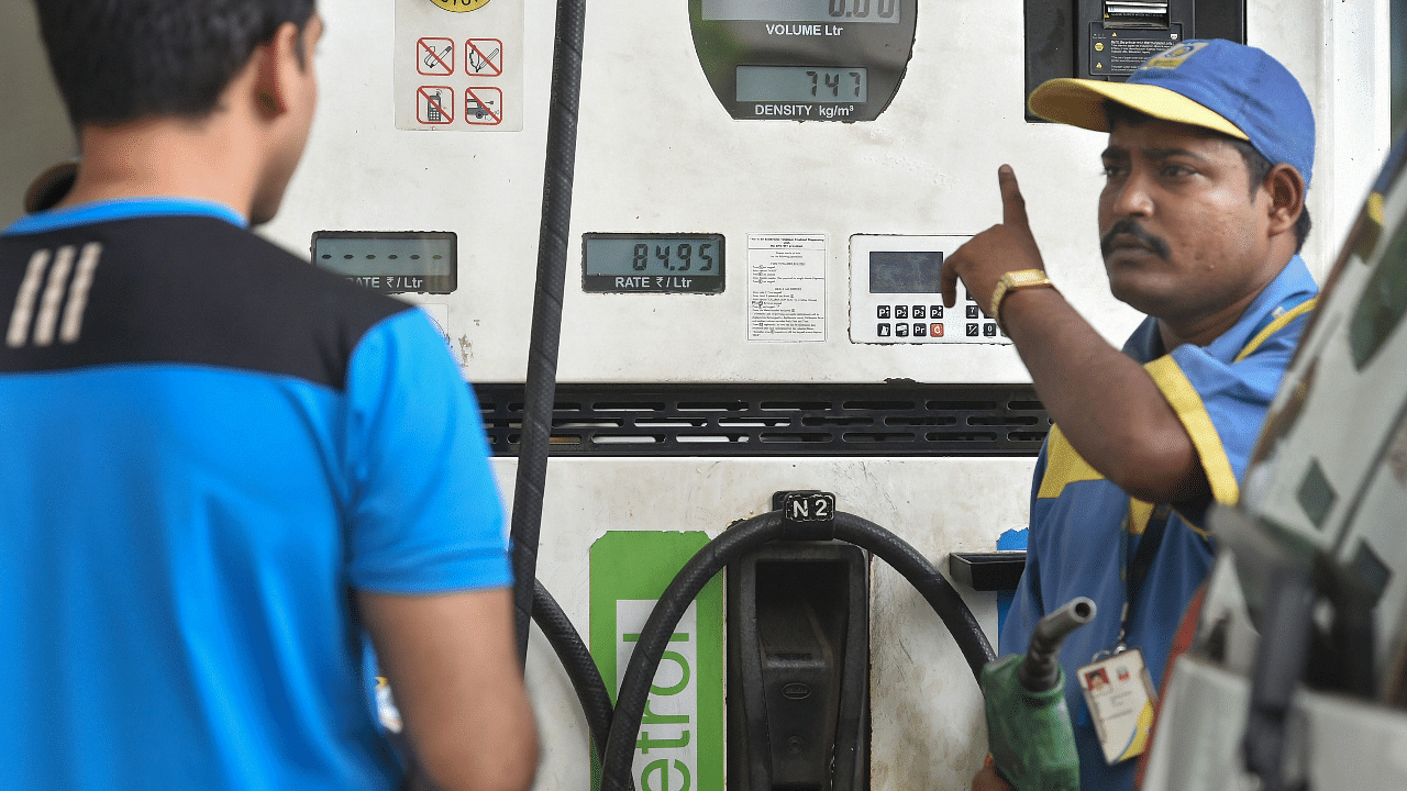 A petrol pump employee serves a customer at a fuel station. Credit: PTI Photo