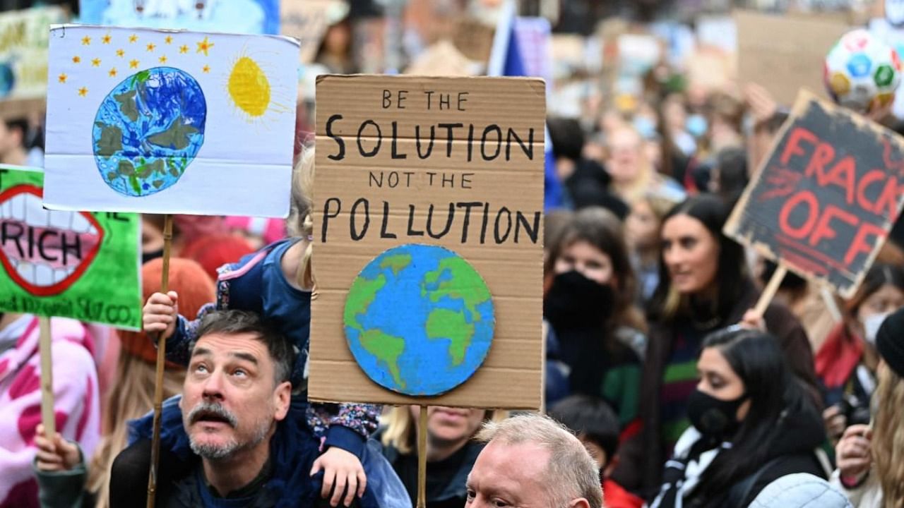 Climate activists carry placards during the Fridays For Future rally in Glasgow, Scotland. Credit: AFP Photo