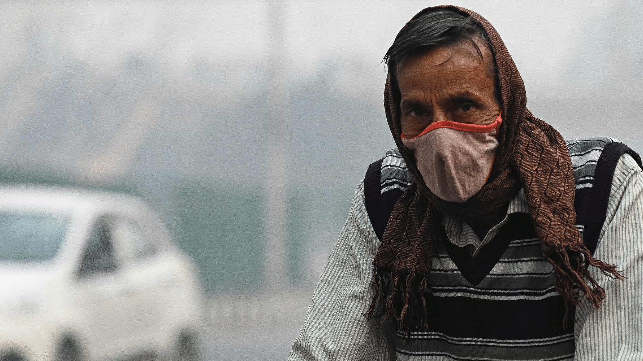 People make their way along a street amid smoggy conditions in New Delhi. Credit: AFP Photo