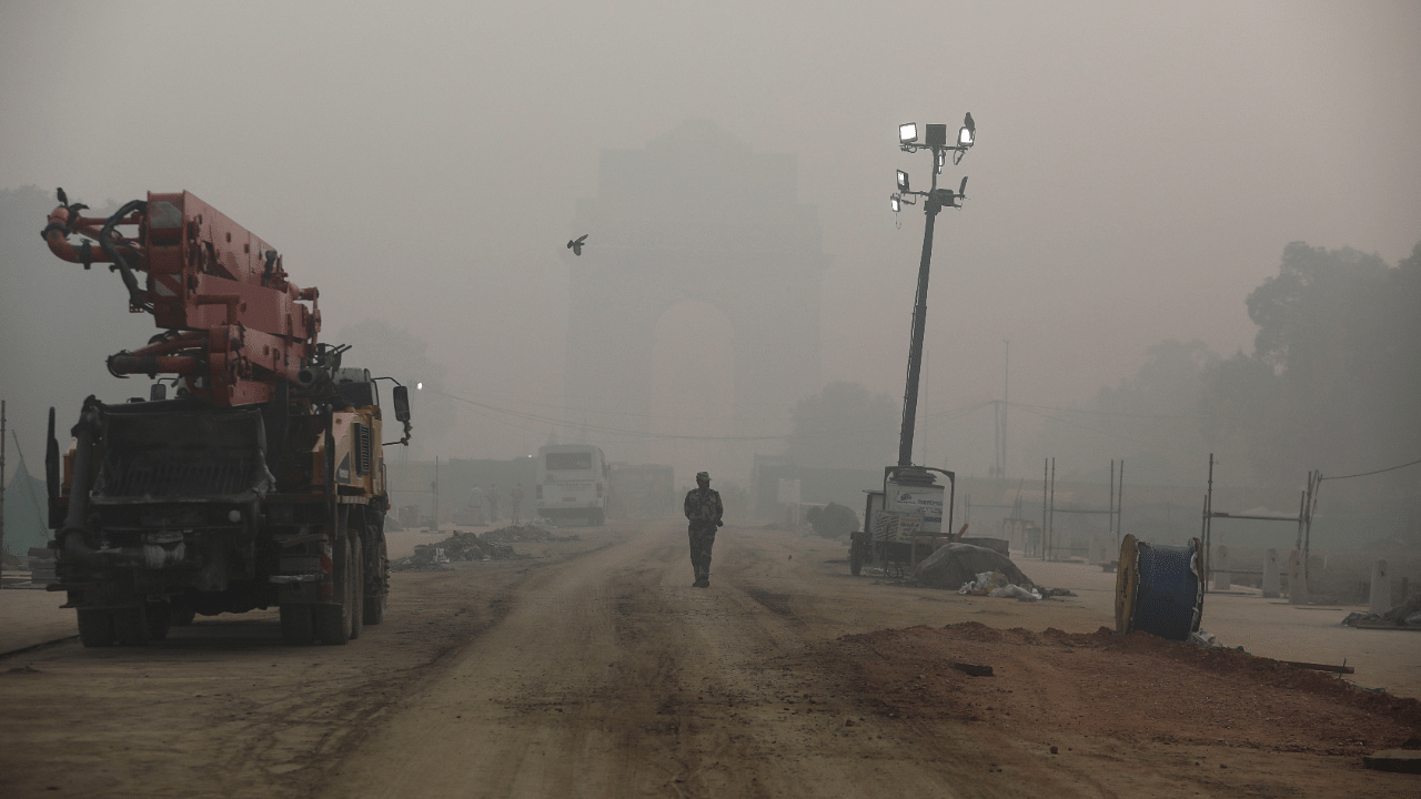 An Indian paramilitary soldier walks near India Gate which is shrouded in smog, in New Delhi. Credit: Reutest Photo