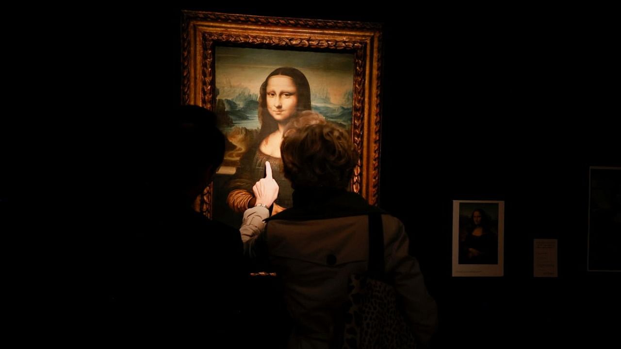 Visitors look at a copy of the Leonardo da Vinci's Mona Lisa, which will go up for auction on November 9, at the Artcurial auction house in Paris. Credit: Reuters photo