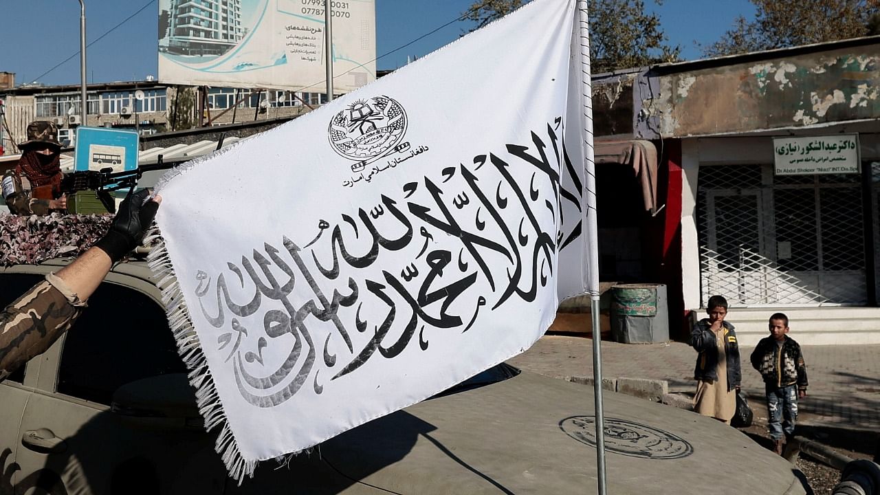 Taliban fighter displays their flag at a checkpoint in Kabul. Credit: Reuters Photo