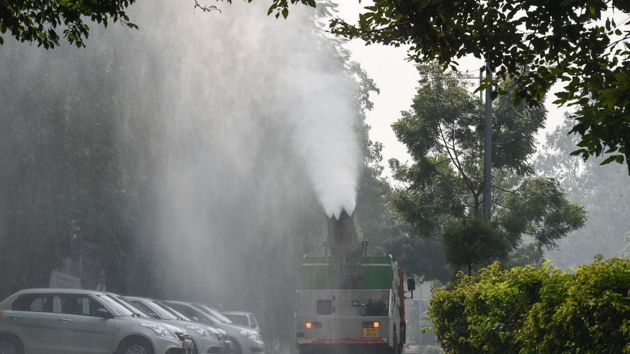 A truck mounted with anti-smog gun is used to spray water droplets to curb air pollution, as a thick layer of smog engulfs the national capital following Diwali celebrations. Credit: PTI Photo