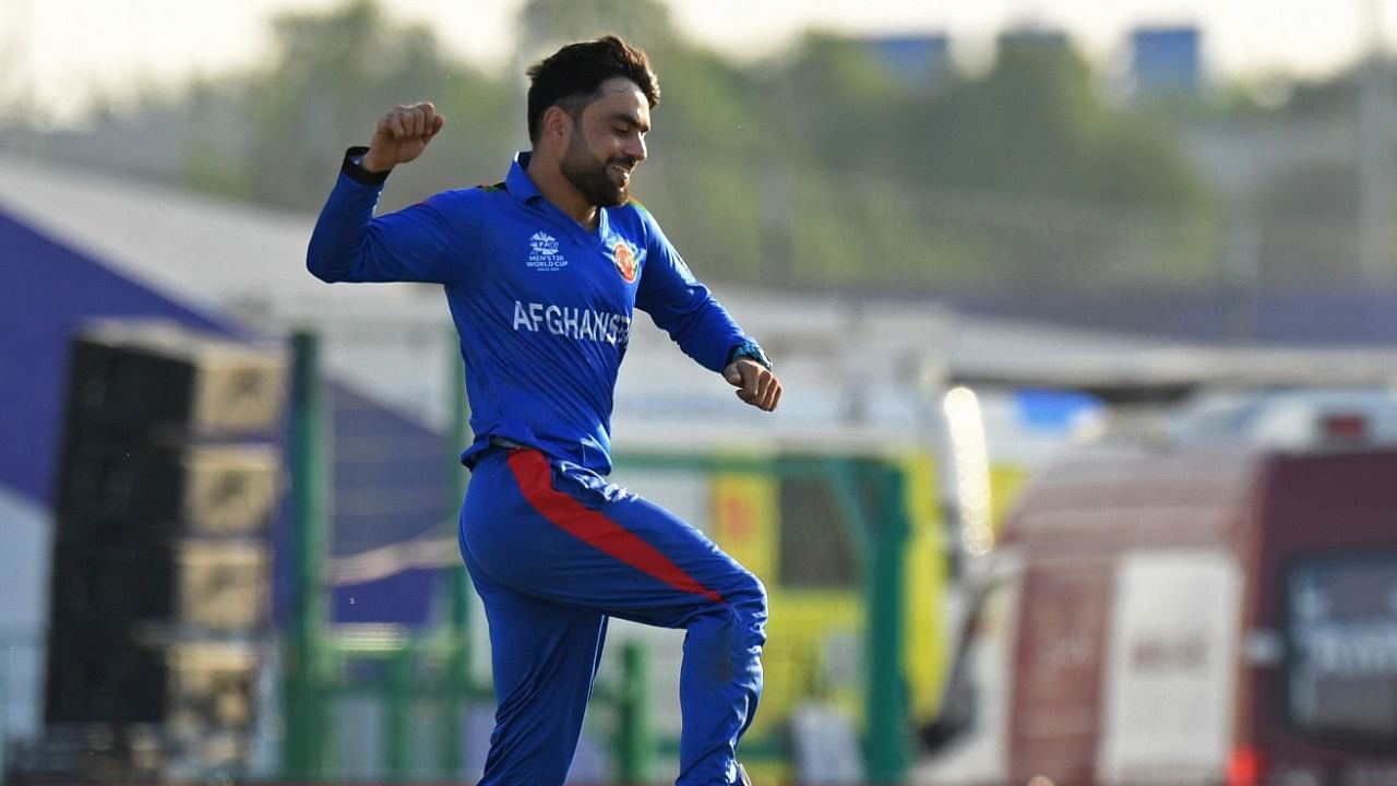 Afghanistan's Rashid Khan (C) celebrates after taking the wicket of New Zealand's Martin Guptill. Credit: AFP Photo