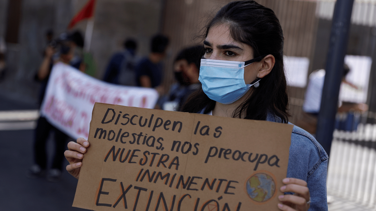 A demonstrator holds a sign reading "Sorry for the inconvenience, we are worried about our imminent extinction" during a protest, as the UN Climate Change Conference (COP26) takes place in Glasgow. Credit: Reuters Photo