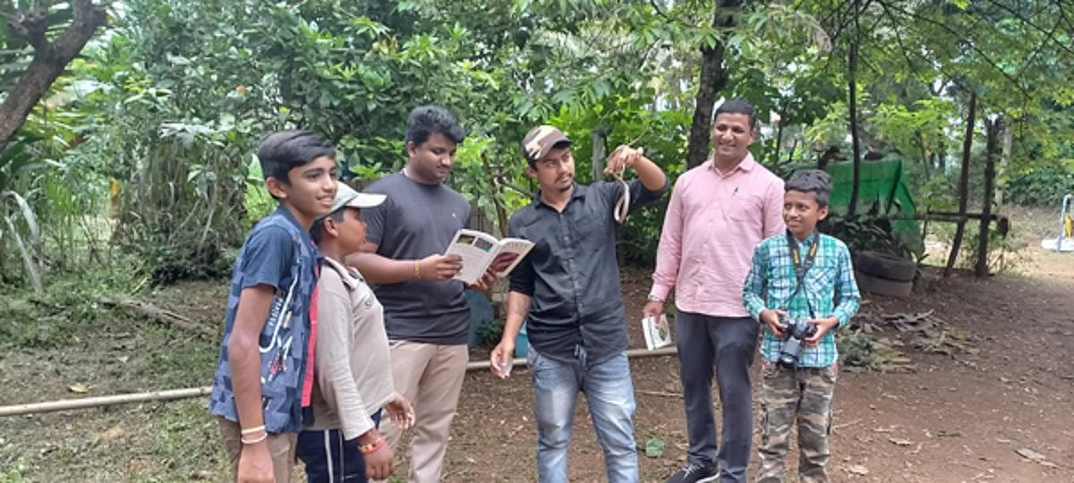 Nishanth P Bellad (wearing a cap) creates awareness about snakes among the children and general public in Kodlipet.