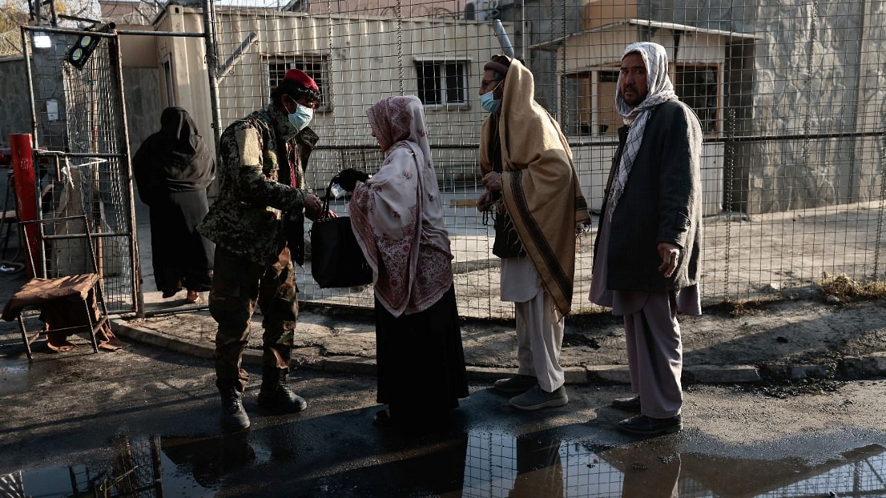 A Taliban fighter checks a woman's bag outside the military hospital. Credit: Reuters File Photo