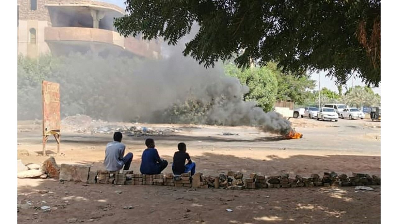 Young Sudanese sit on a street barricades built overnight by anti-coup demonstrators in the capital Khartoum, following calls for civil disobedience to protest last month's military coup. Credit: AFP Photo