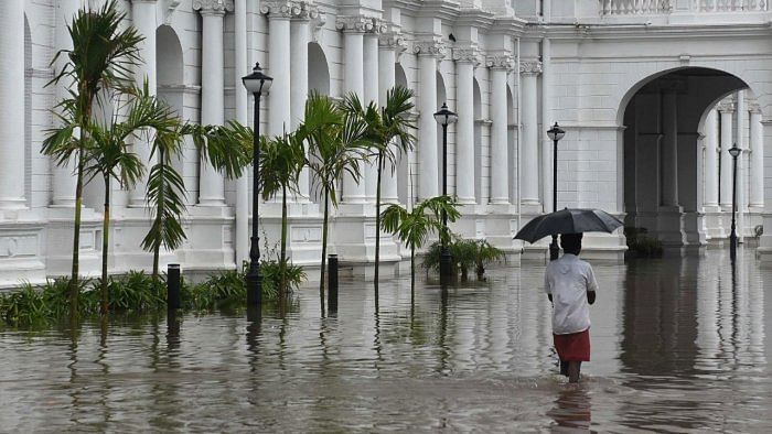 A man walks through the flooded complex of Ripon Building during a rain shower in Chennai on November 7, 2021. Credit: AFP Photo