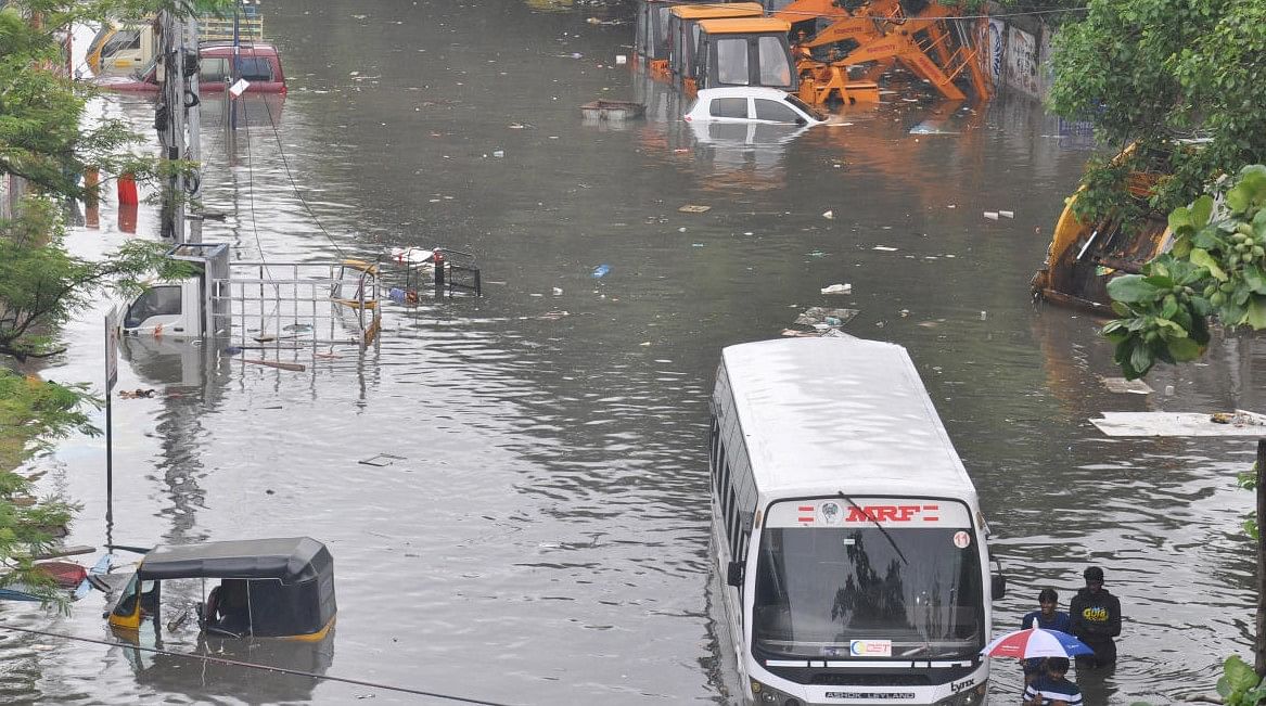 Chennai: Commuters wade through a waterlogged area following heavy rain in Chennai, Sunday, Nov. 7, 2021. A flood alert has been sounded to people living in Chennai suburbs. (PTI Photo)