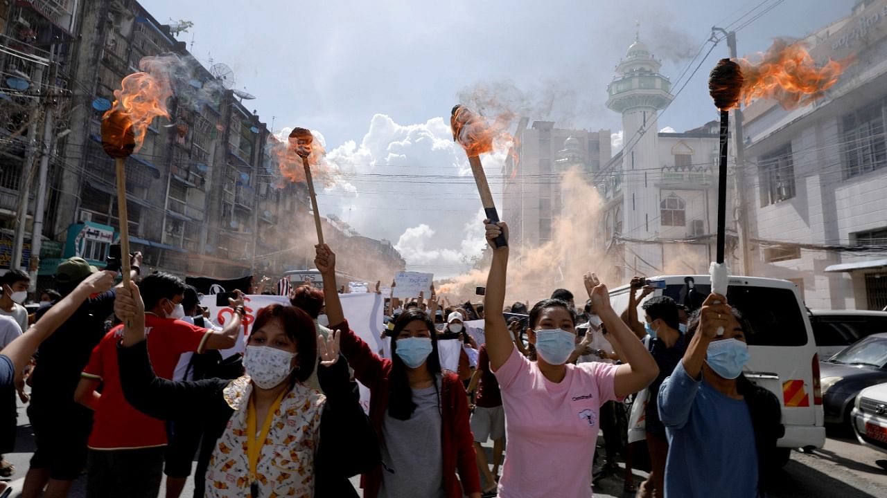 A group of women hold torches as they protest against the military coup in Yangon, Myanmar. Credit: Reuters File Photo
