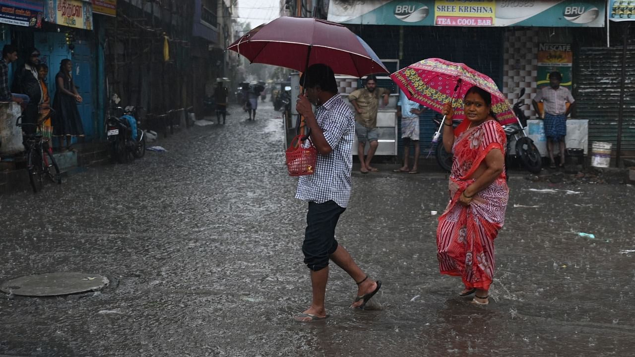 People wade through a flooded street after heavy monsoon rains in Chennai on November 8, 2021. Credit: AFP File Photo