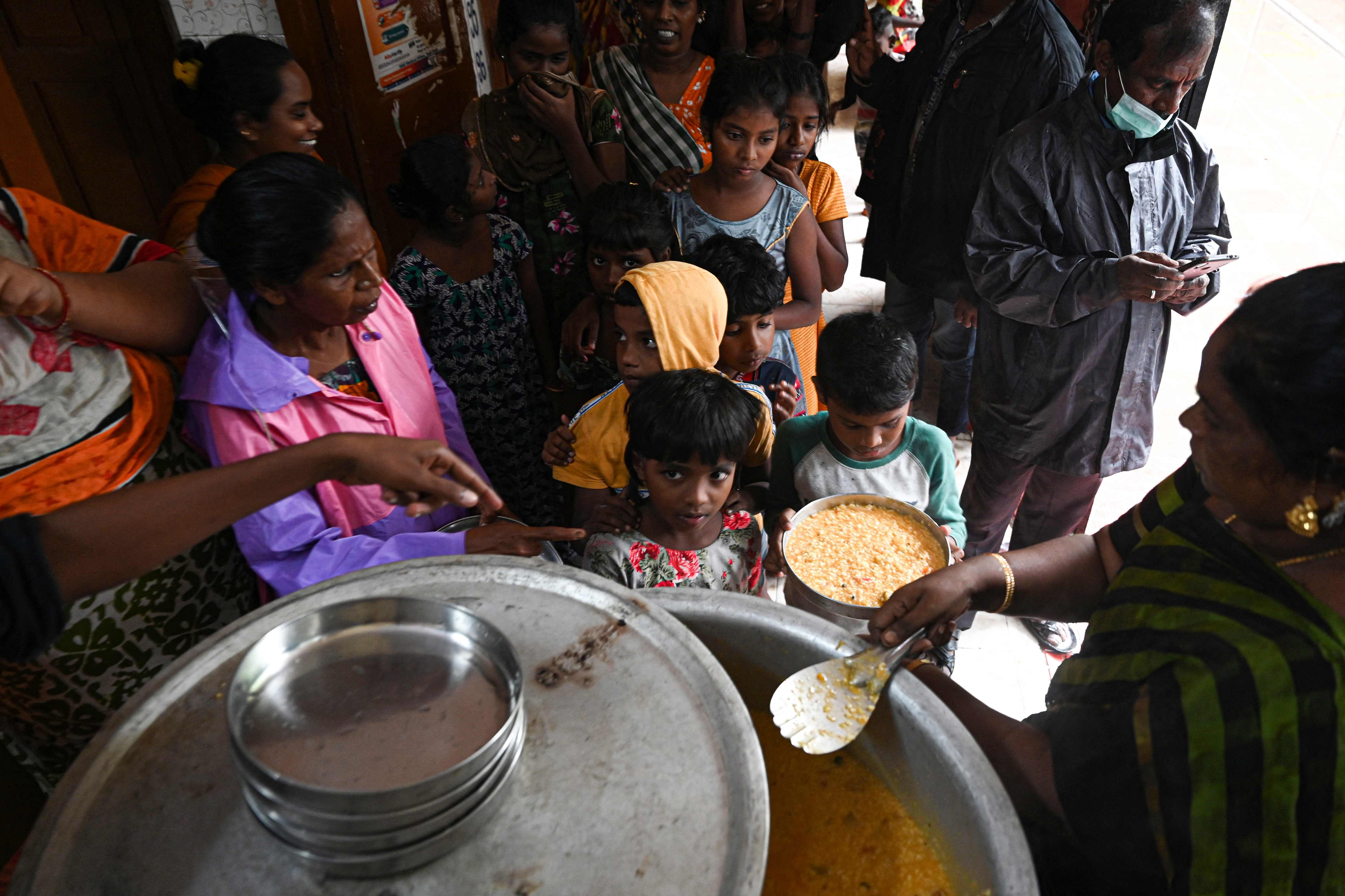 Civic authorities distribute food to residents at a temporary shelters after heavy monsoon rains in Chennai. Credit: AFP Photo