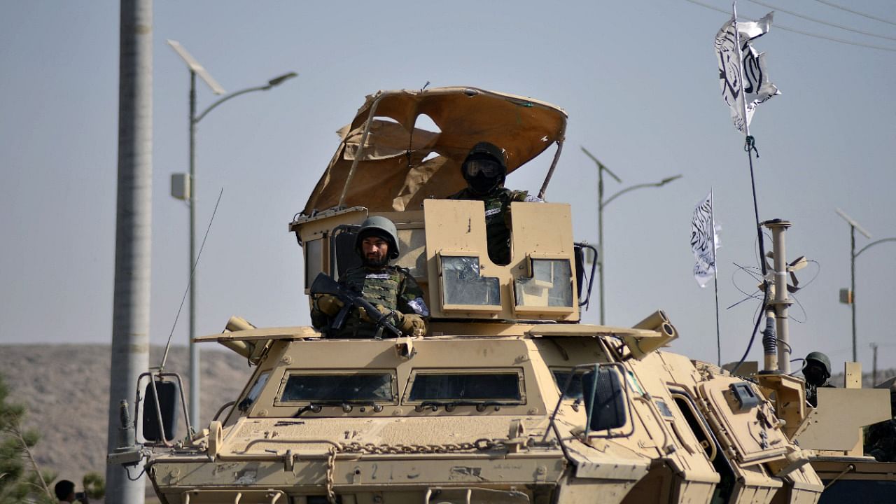 Taliban military from the Al-Badr unit sit on armed vehicles during a parade in Kandahar on November 8, 2021. Credit: AFP Photo