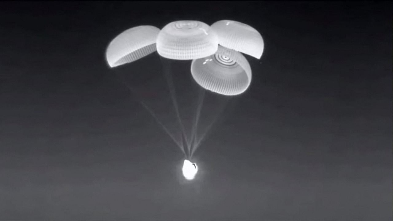 This screen grab taken from the SpaceX live webcast shows the Crew-2 SpaceX Dragon capsule dubbed "Endeavour" with its parachutes deployed just before splashing down off the coast of Pensacola, Florida, on November 8, 2021. Credit: AFP Photo