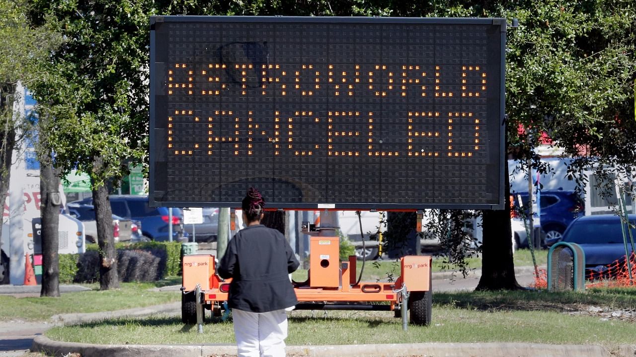 A pedestrian cross Main Street in front of a sign announcing the cancellation of Astroworld on Saturday, Nov. 6, 2021, in Houston. Credit: AP/PTI Photo