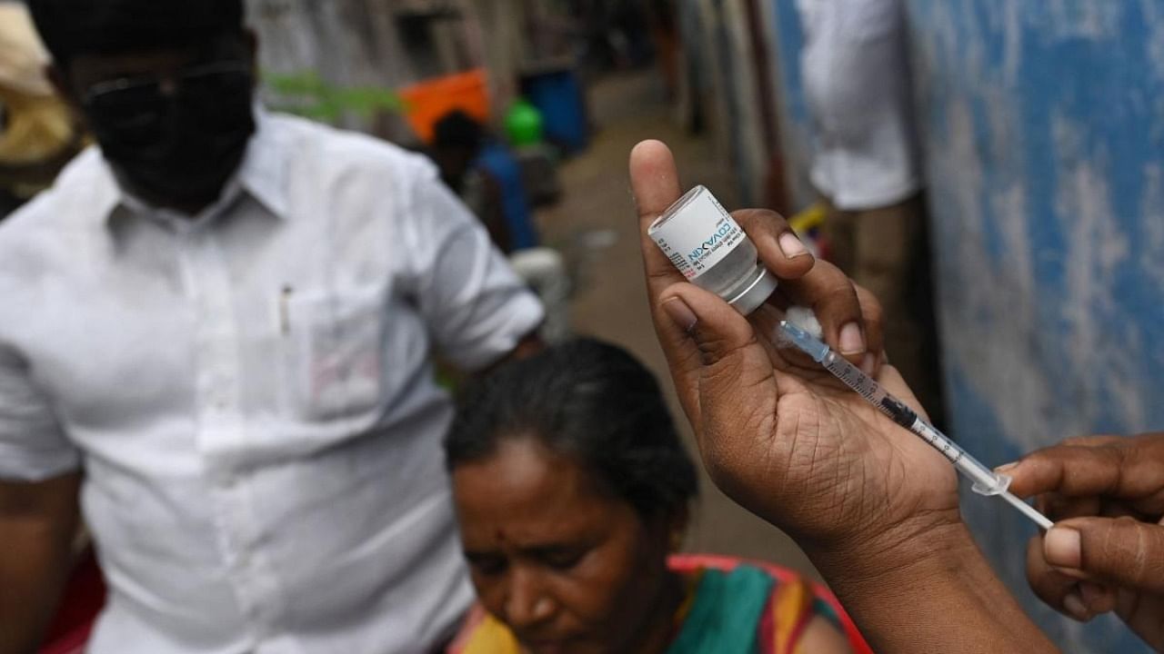 A health worker prepares to inoculate a resident with a dose of the Covaxine vaccine against Covid-19 coronavirus during a door-to-door vaccination drive at a slum in Chennai. Credit: AFP Photo