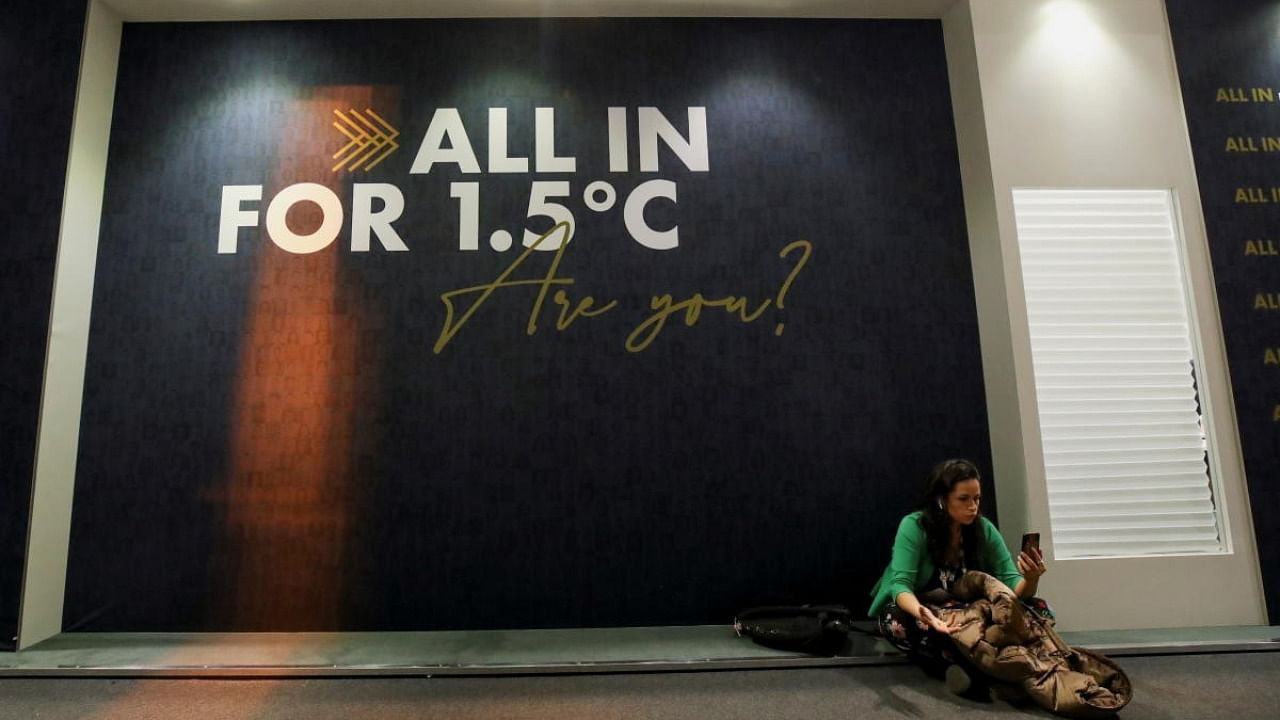 A delegate sits in front of a wall with a message during the UN Climate Change Conference (COP26) in Glasgow. Credit: Reuters photo