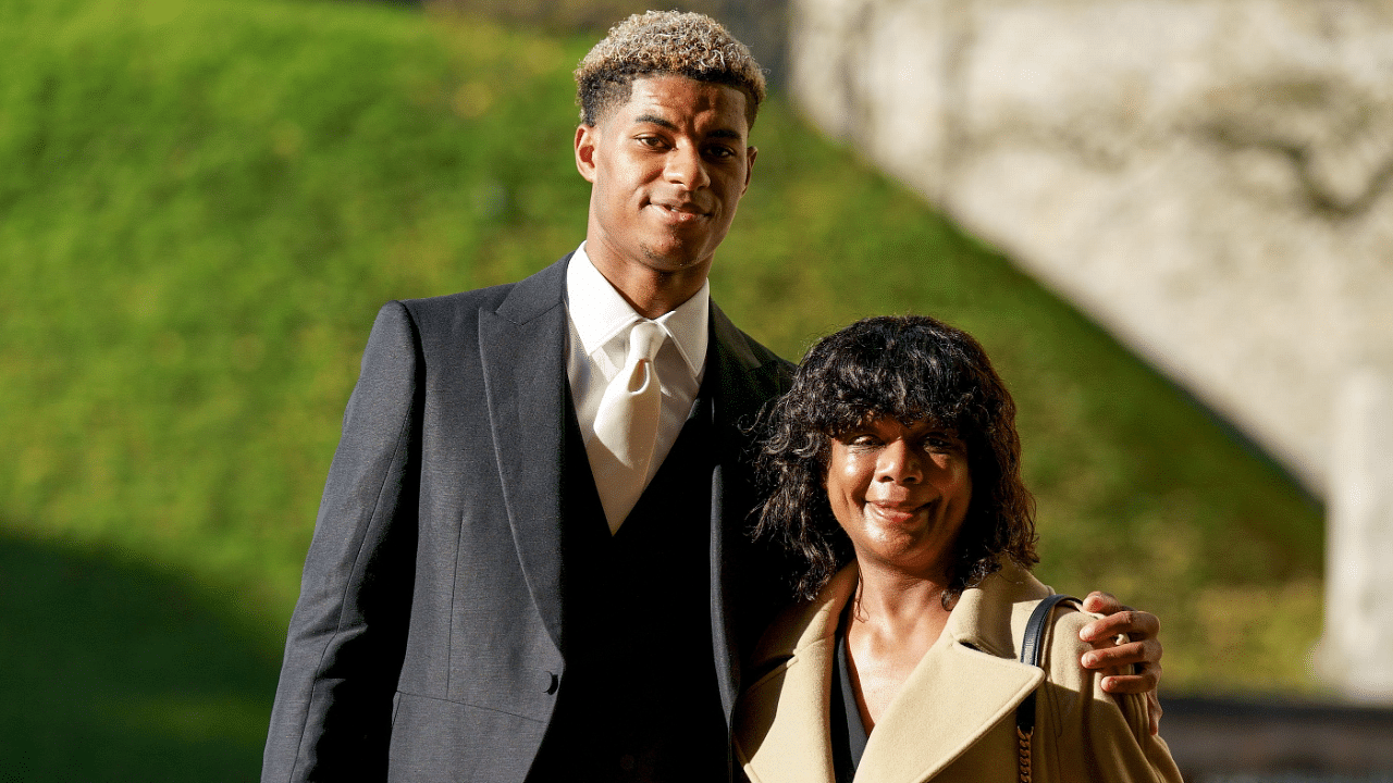 Footballer Marcus Rashford poses with his mother Melanie Rashford before receiving his Most Excellent Order of the British Empire (MBE). Credit: Reuters Photo