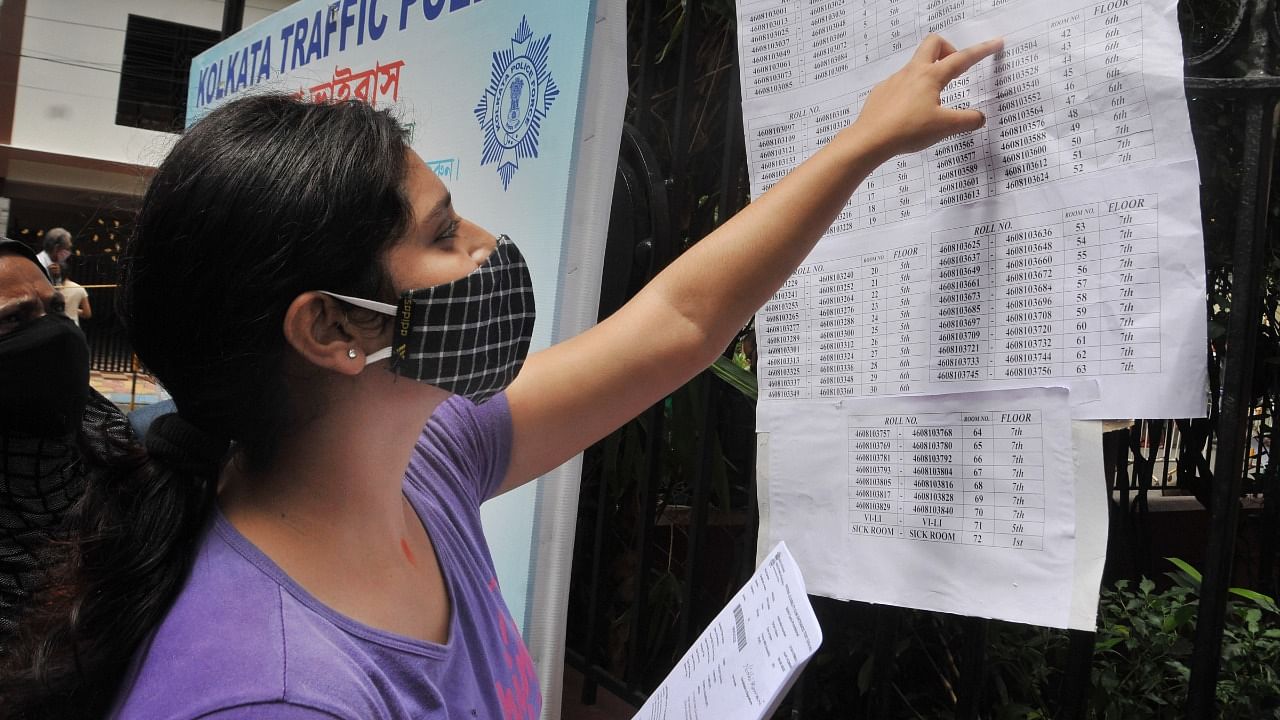 An aspirant looks for her seat number before appearing in NEET at an examination centre in Kolkata. Credit: PTI File Photo