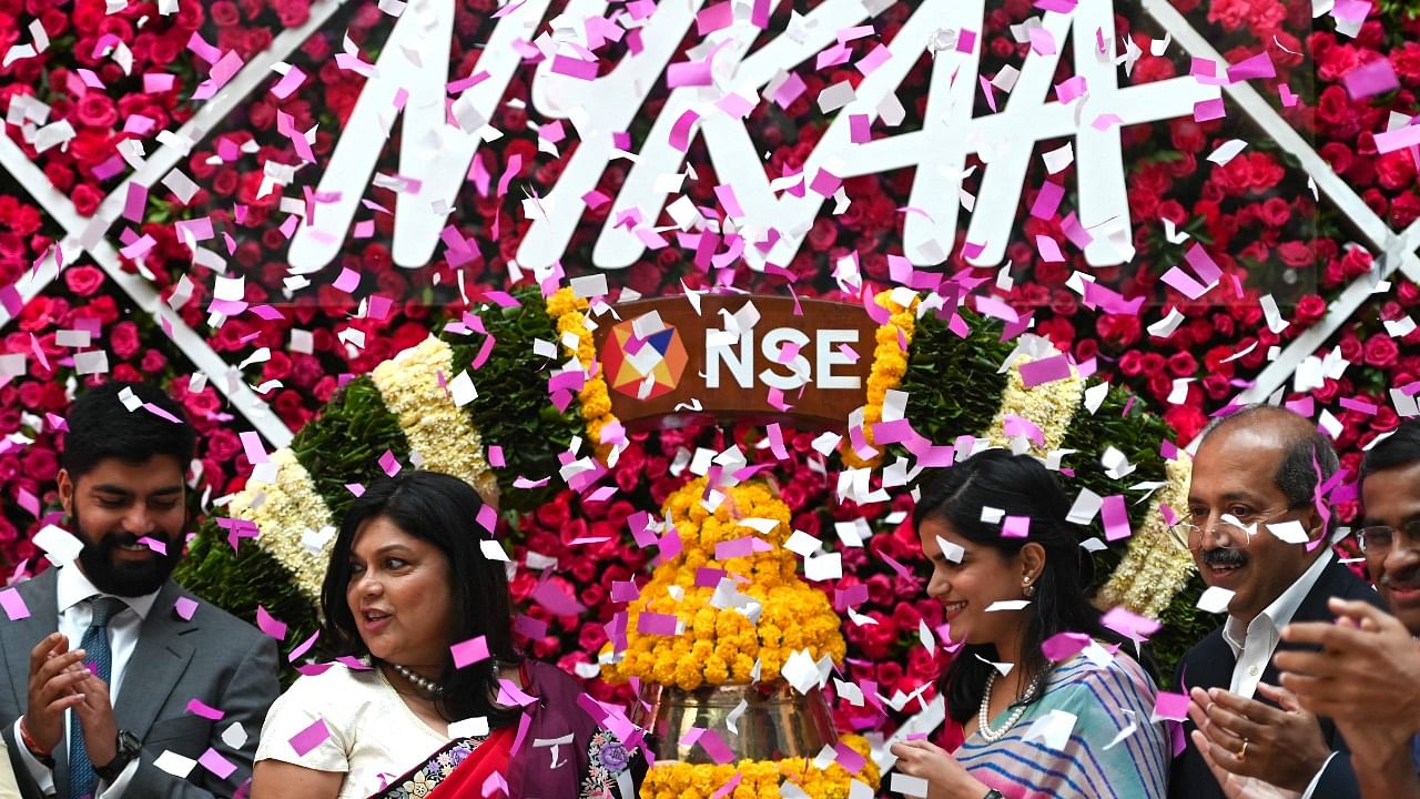 Falguni Nayar (C-L), managing director and CEO of Nykaa, an online marketplace for beauty and wellness products, along with her daughter Advaita (C-R) attends the company's IPO listing ceremony at the National Stock Exchange in Mumbai on November 10, 2021. Credit: AFP Photo