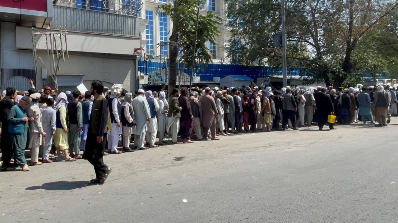 Afghans line up outside a bank to take out their money. Credit: Reuters file photo