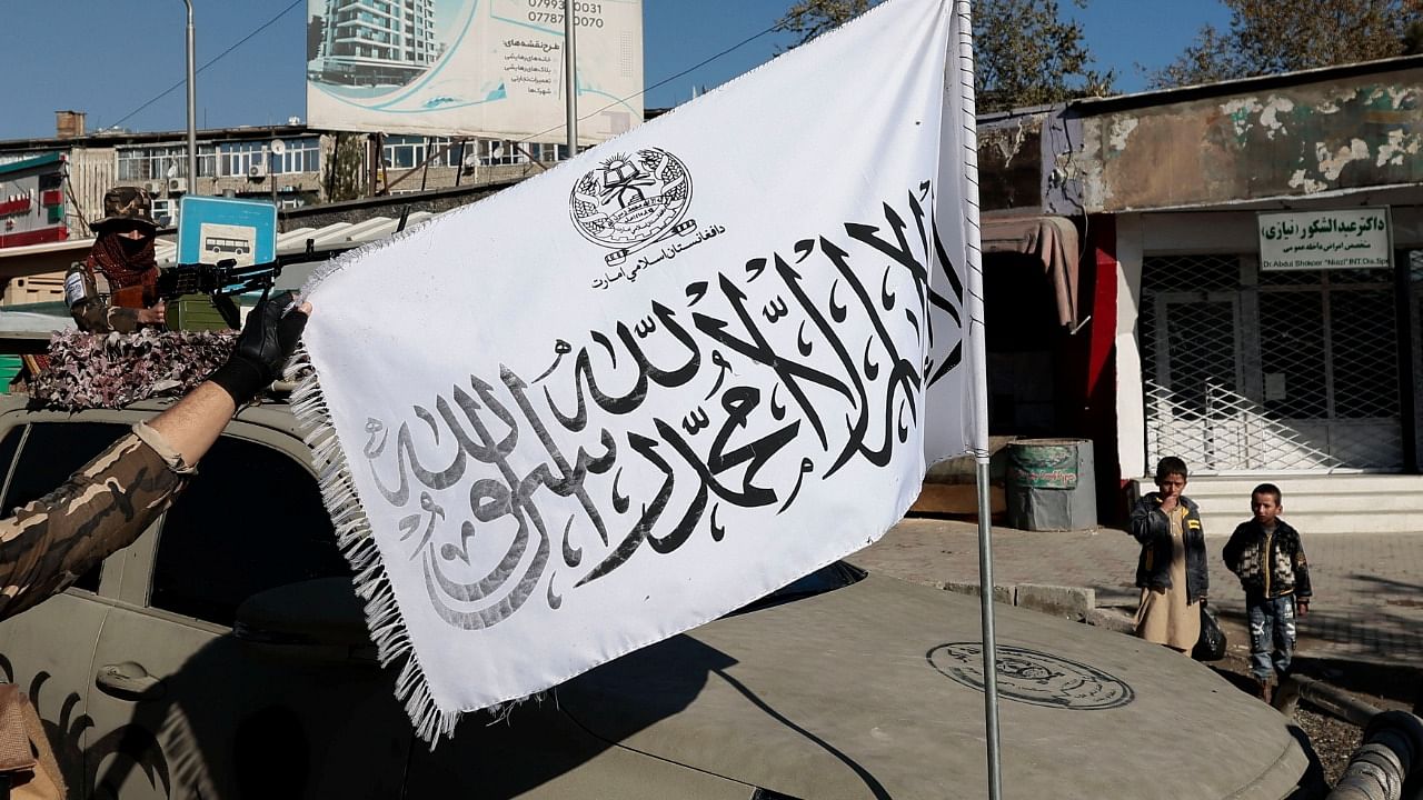 Taliban fighter displays their flag at a checkpoint in Kabul. Credit: Reuters File Photo