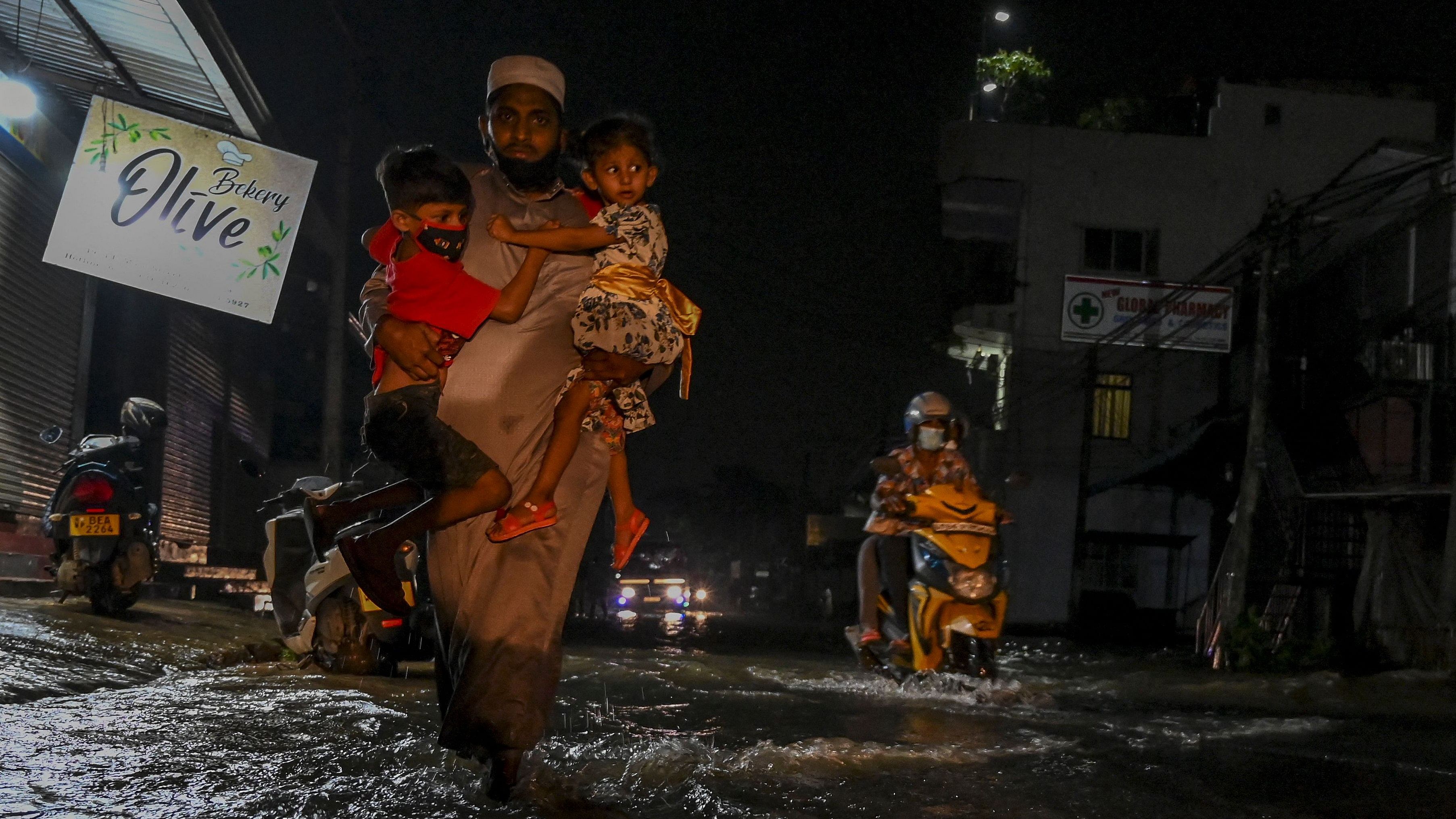 Residents wade through a flooded street after a heavy monsoon rainfall at Malwana, outside the capital Colombo. Credit: AFP Photo
