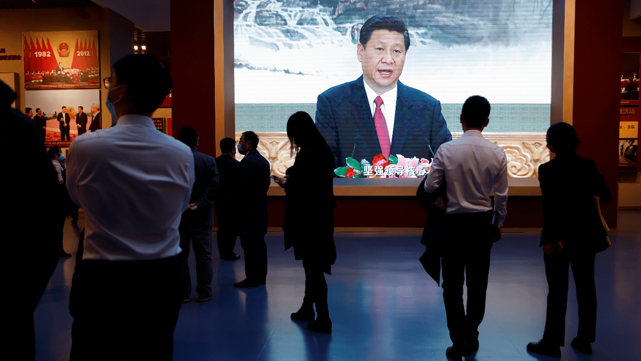 Visitors stand near a screen showing an image of Chinese President Xi Jinping.  Credit: Reuters Photo