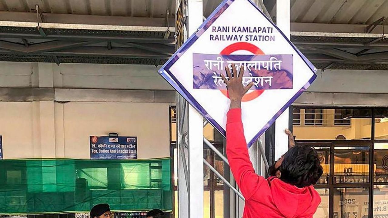 A worker installs a nameplate after Habibganj railway station renamed as Rani Kamlapati railway station. Credit: PTI Photo