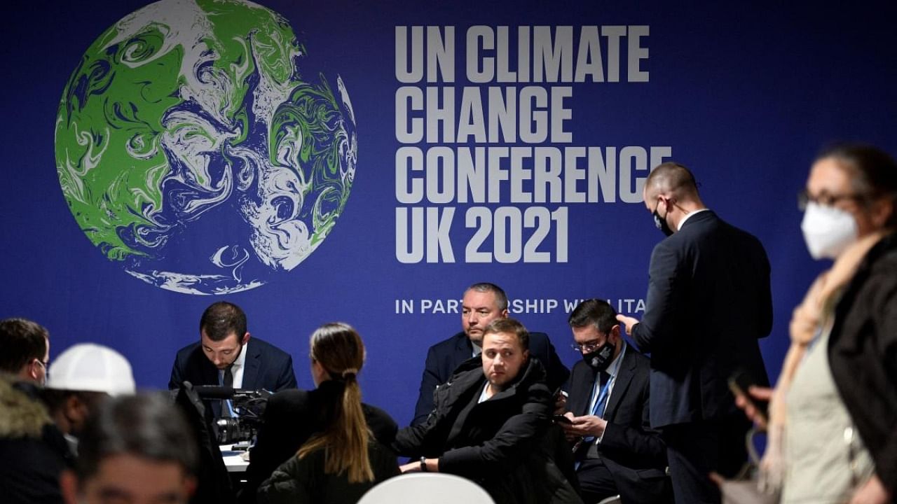 Delegates sit beneath a logo during the COP26 UN Climate Change Conference in Glasgow, Scotland. Credit: AFP Photo