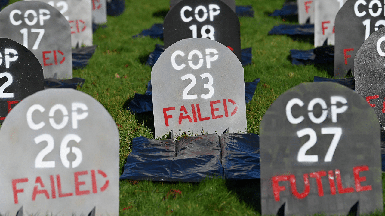 Mock headstones are pictured at Glasgow Necropolis to symbolise the failure of the COP26 process, at Glasgow Cathedral in Glasgow. Credit: AFP Photo