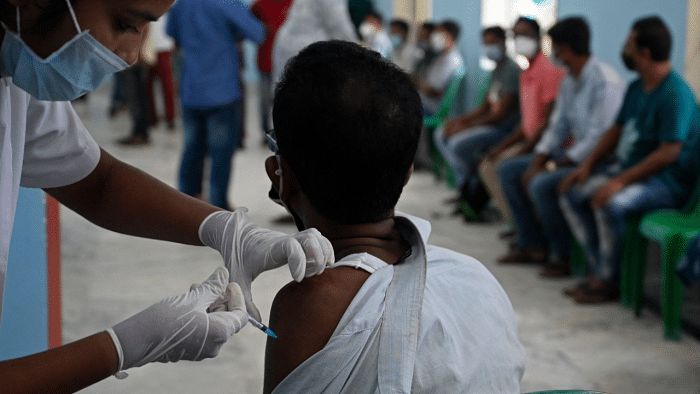 A health worker inoculates a man with a dose of the Covid-19 vaccine. Credit: AFP Photo
