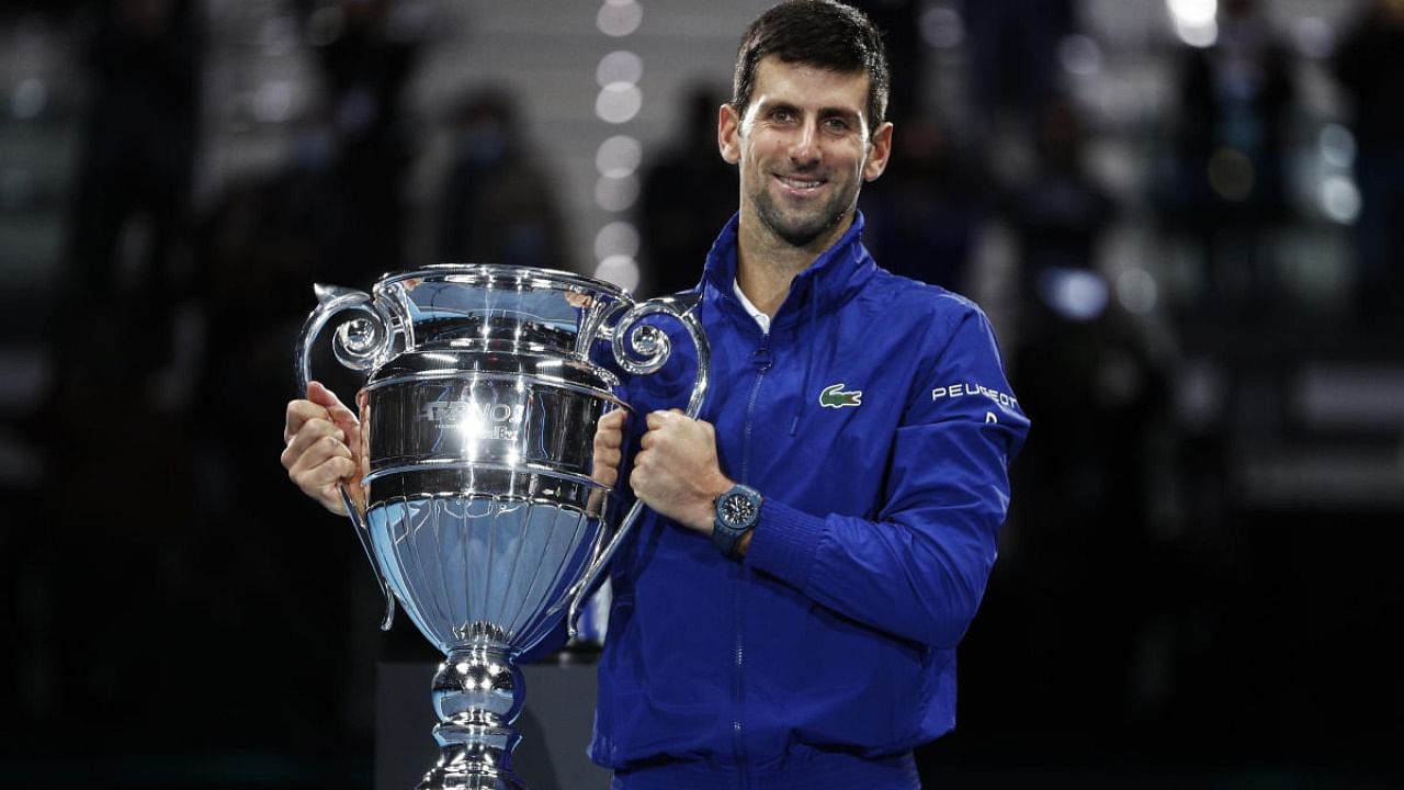 Serbia's Novak Djokovic poses as he celebrates with the trophy for his 2021 world number one ranking after winning his group stage match against Norway's Casper Ruud. Credit: Reuters photo