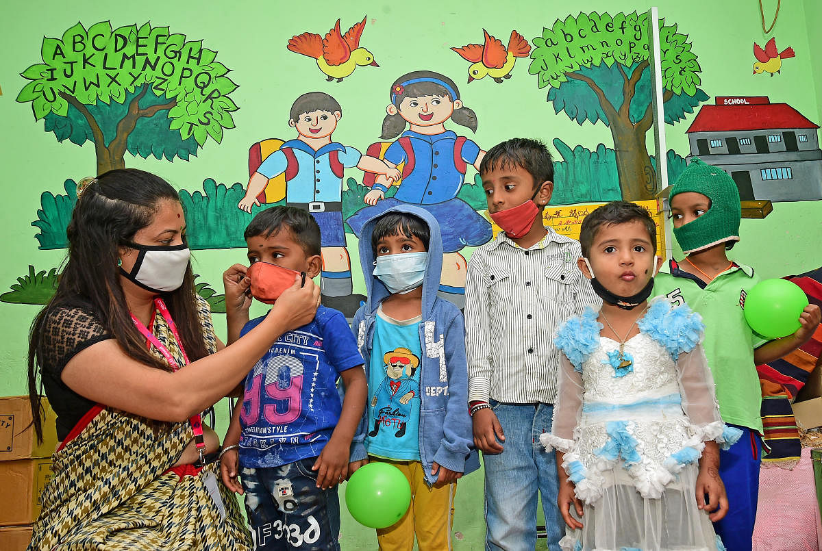 A teacher helping children with their masks. Ranju P