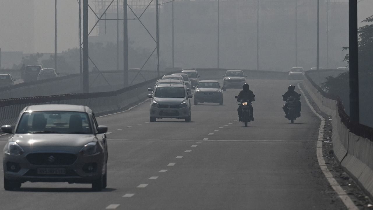 Commuters drive along a road amid heavy smog in New Delhi on November 16, 2021. Credit: AFP File Photo