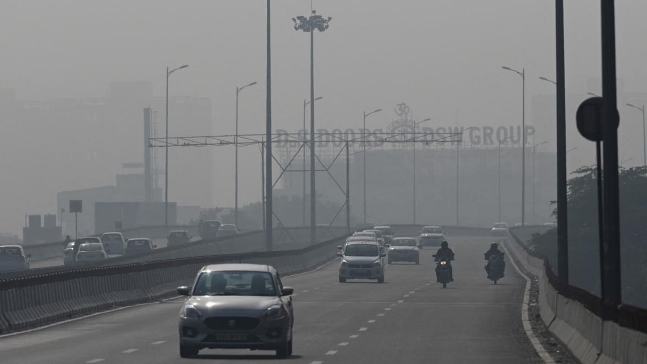 Commuters drive along a road amid heavy smog in New Delhi. Credit: AFP Photo