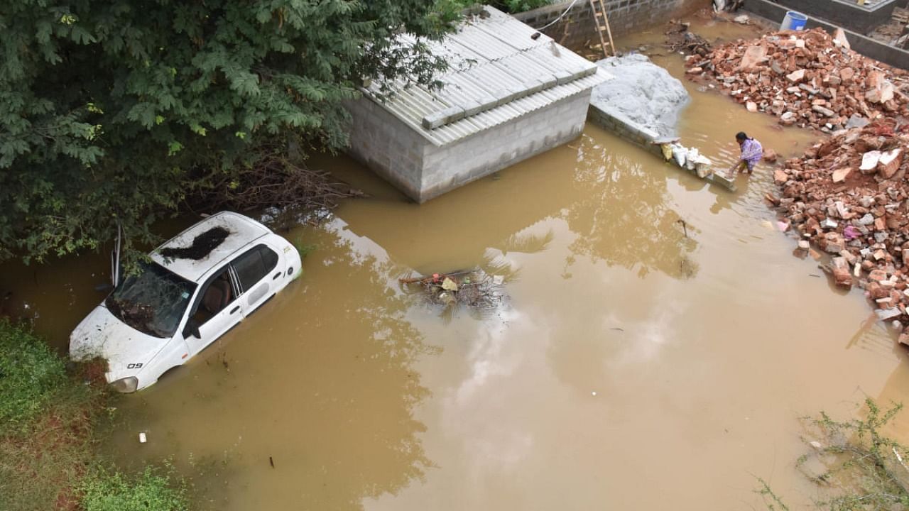 A car submerged at Amco Layout following a heavy downpour in the city on Tuesday. DH Photo/B K Janardhan