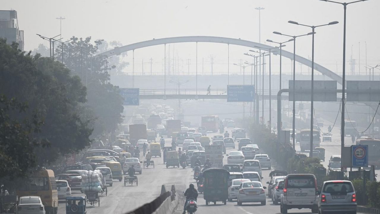 Commuters make their way along a road amid heavy smog in New Delhi. Credit: AFP Photo