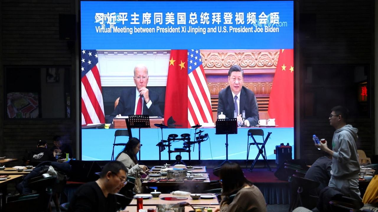 Screen shows Chinese President Xi Jinping attending a virtual meeting with U.S. President Joe Biden via video link, at a restaurant in Beijing. Credit: Reuṭers Photo