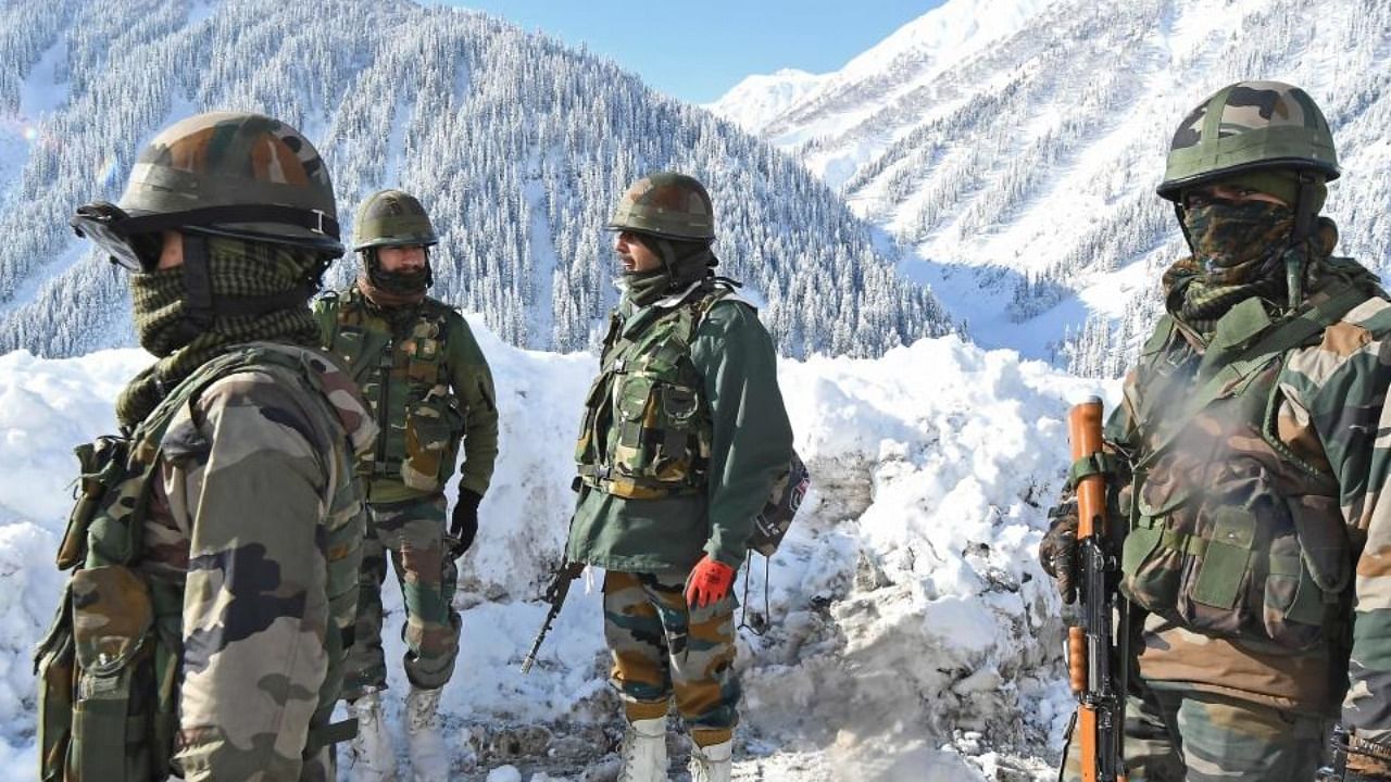 Indian army soldiers stand on a snow-covered road near Zojila mountain pass that connects Srinagar to the union territory of Ladakh, bordering China. Credit AFP Photo