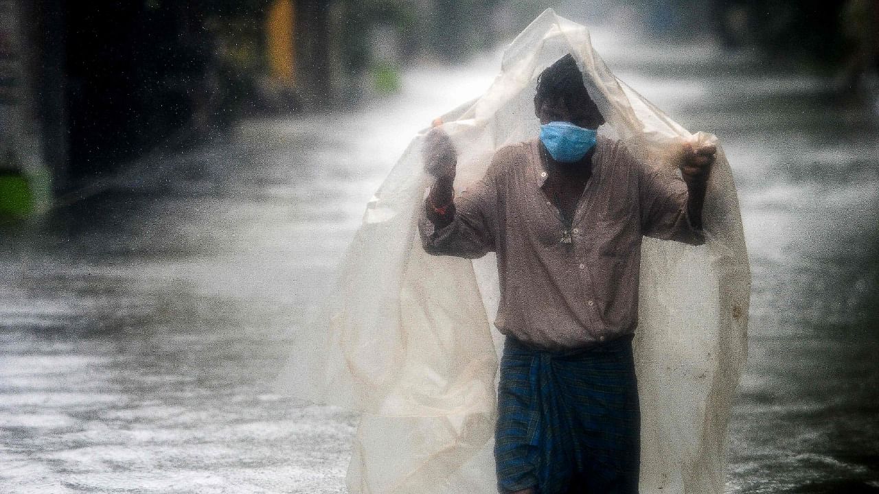 A man walk along a waterlogged street during a heavy monsoon rainfall in Chennai on November 11, 2021. Credit: AFP Photo