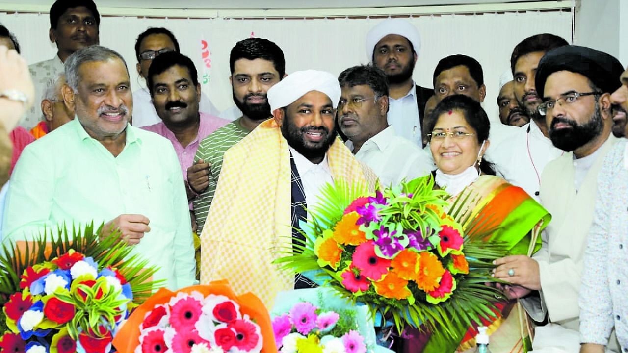 Wakf Minister Shashikala Jolle congratulates Maulana Shafi Saadi on latter’s election as Wakf Board chairperson, in Bengaluru on Wednesday. Law and Parliamentary Affairs Minister J C Madhuswamy is also seen. Credit: Wakf minister’s office