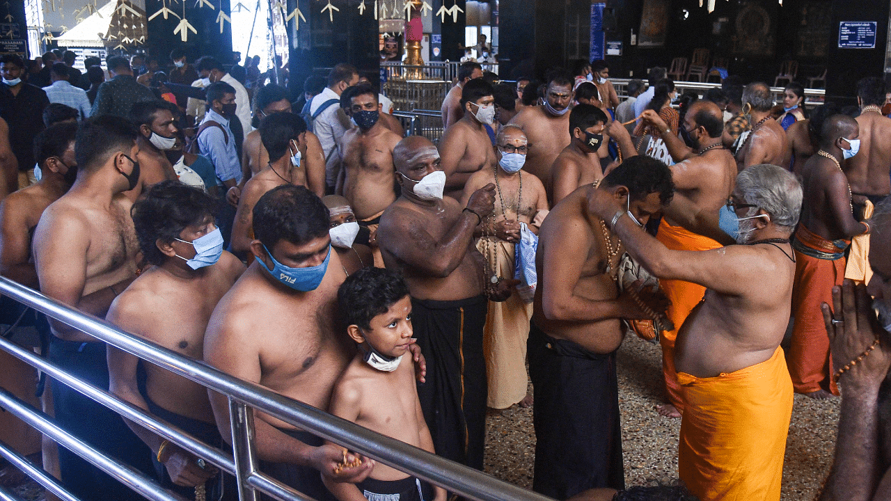 Devotees wear the sacred necklace at a Lord Ayyappa temple before their pilgrimage to Kerala's Sabarimala temple. Credit: PTI Photo