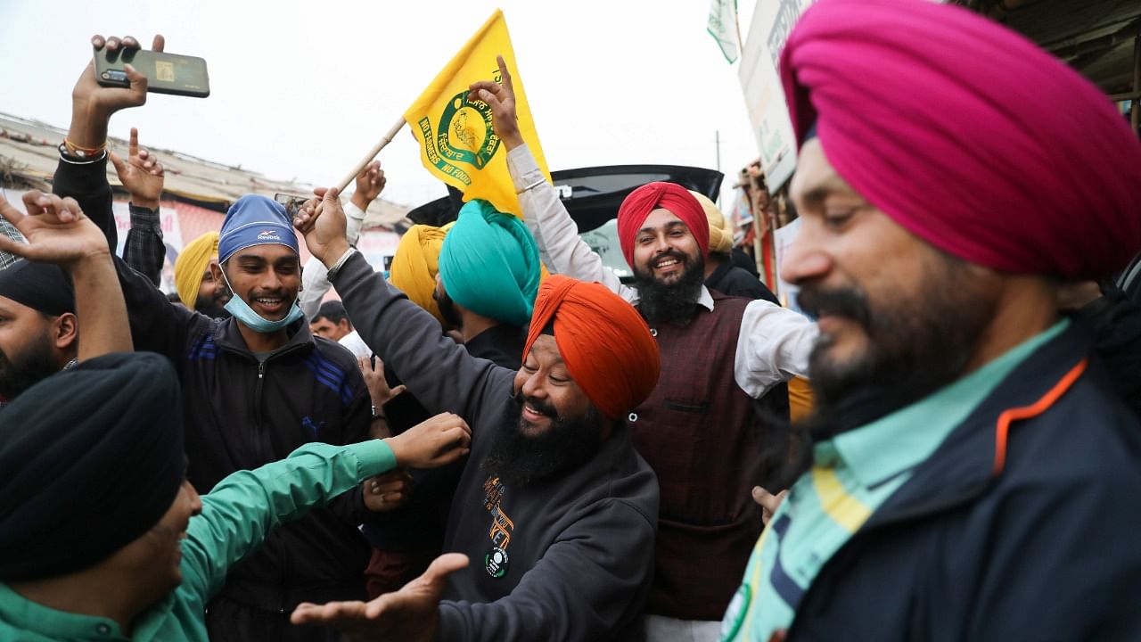 Farmers celebrate after PM Modi announced that he will repeal the controversial farm laws, at the Singhu border farmers protest site near Delhi-Haryana border. Credit: Reuters File Photo