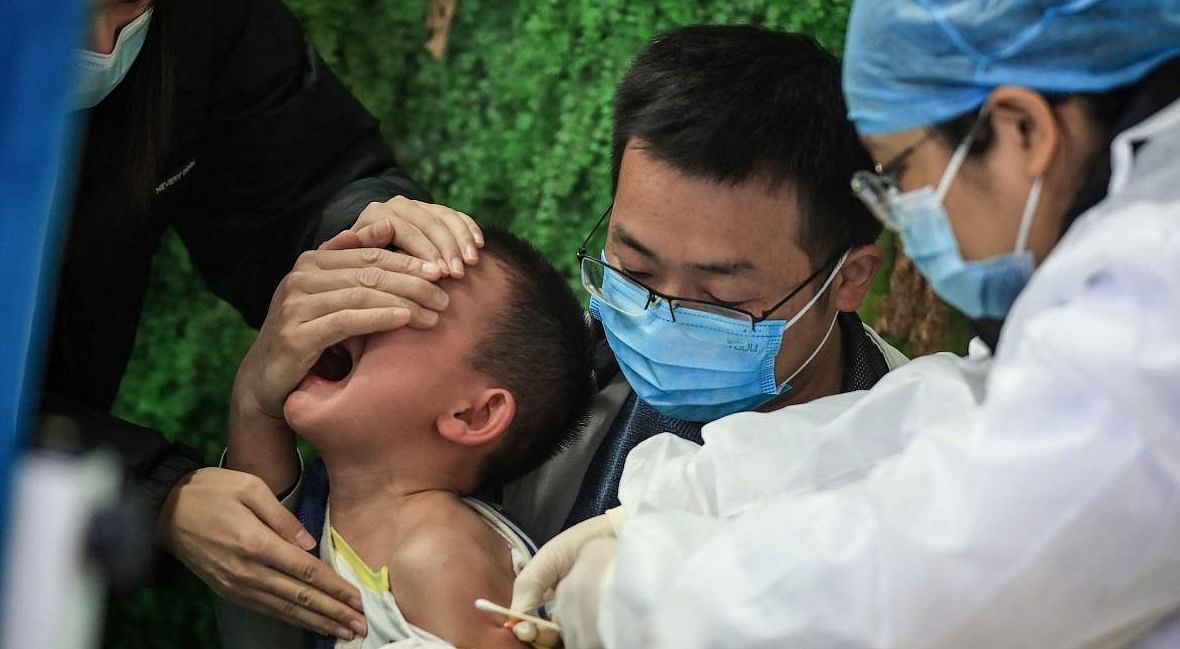 A child receives a Covid-19 coronavirus vaccine in Wuhan. Credit: AFP Photo